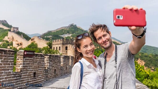Travelers on the Great Wall of China taking a photo with their mobile phone