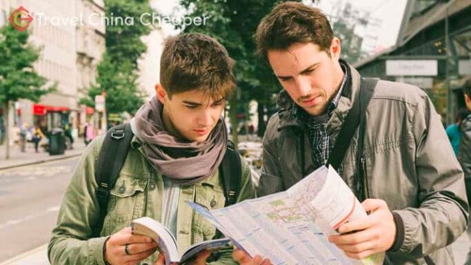 Two travelers using a physical travel map in China.
